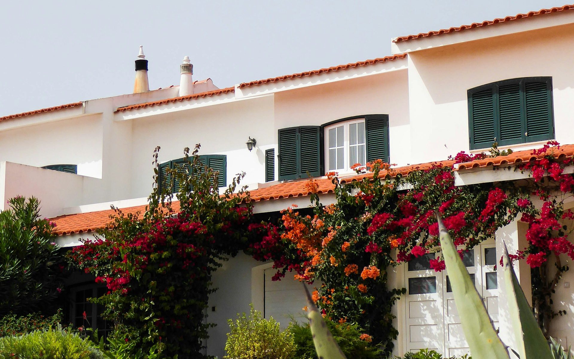 a house with a fence and bushes