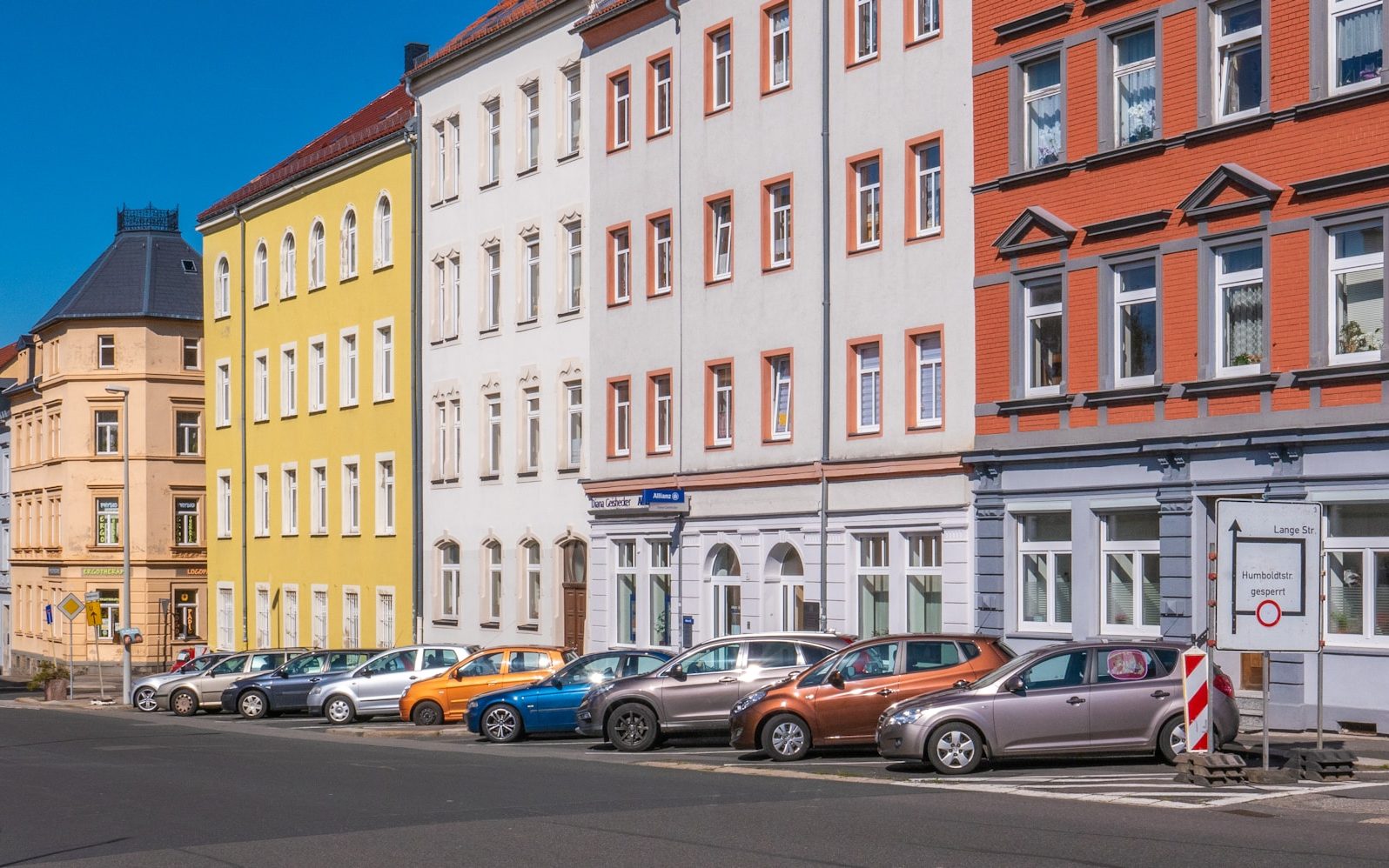 assorted-color cars parked beside apartments